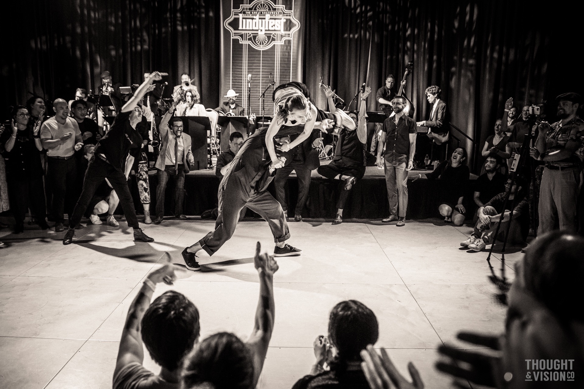 Shane Dickens performing with the band at Lindyfest as swing dancers perform